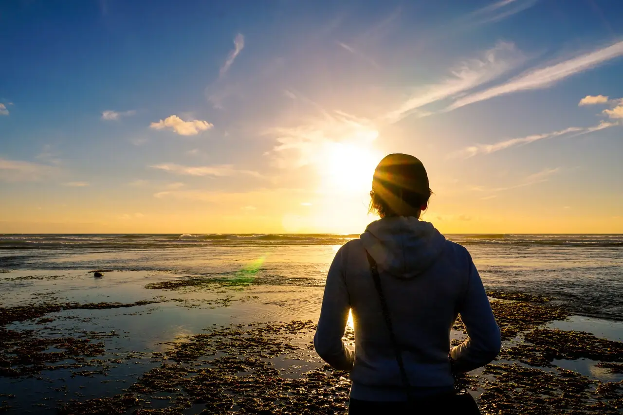 Asian young healthy woman looking far away during the sunset at the beach. Strong confidence woman under the sunset at seaside.